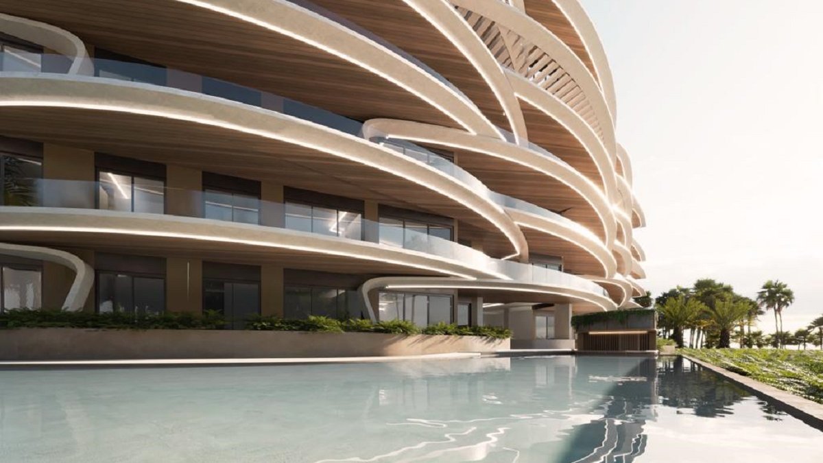 Rendering of a curved residence building at Puerto Marina, Marina Cap Cana, seen across the pool; the 97-residence community delivers in 2029.